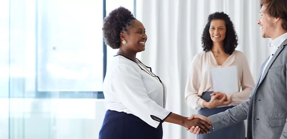 A woman greets man with a handshake in a security company in usa