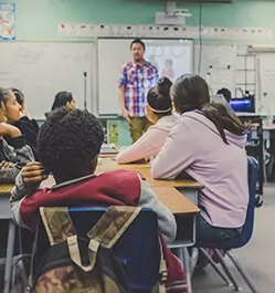 Teacher in a classroom with students using security specialists solutions for education